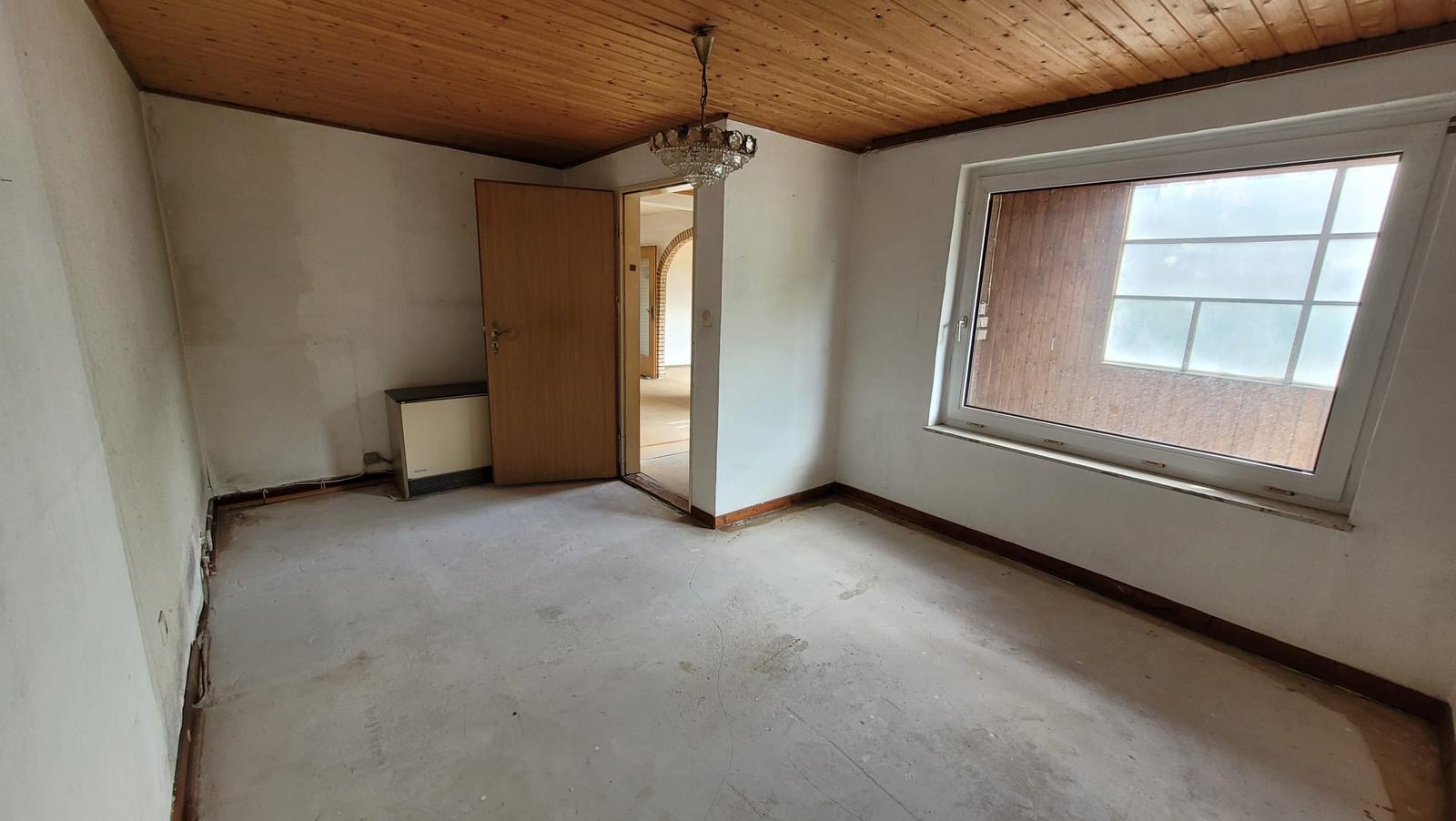 Zimmer vor der Renovierung mit Holzdecke